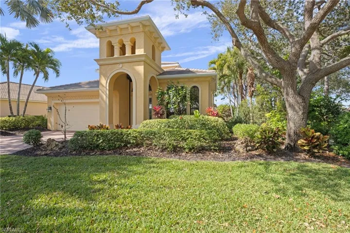 Attractive front elevation showcasing classic stucco siding, a two-car attached garage, manicured front lawn, and an inviting paver driveway.