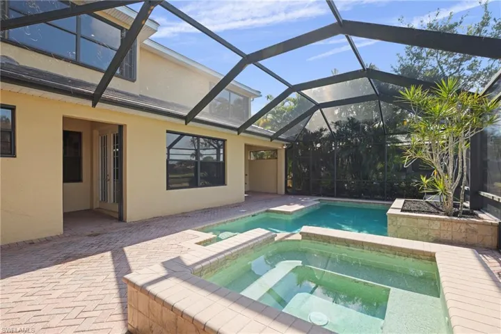 Resort-style private personal pool and spa complemented by a patio room ideal for an outdoor kitchen, creating the perfect setting for embracing the Florida lifestyle.