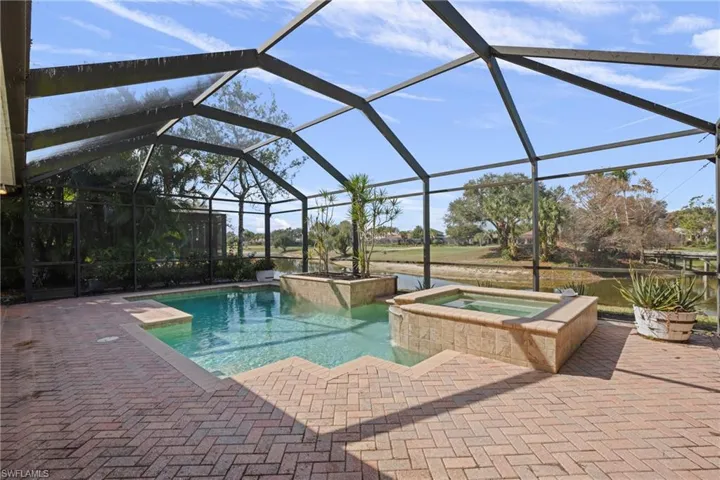 Integrated pool / hot tub with a sunroom, glass enclosure, and a patio
