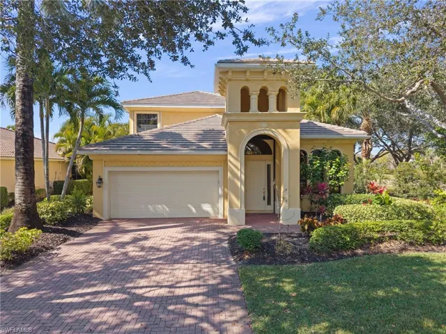 View of front of home featuring stucco siding, an attached 2 car garage, front lawn, and paver driveway