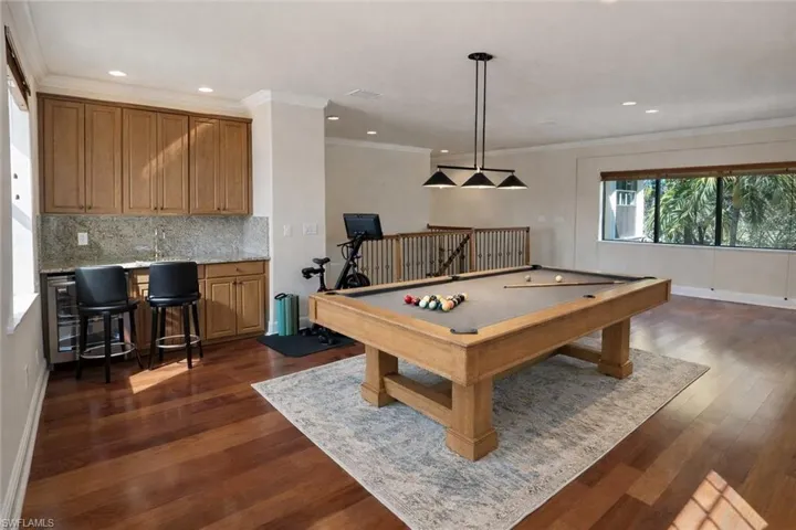 Virtually Staged Loft/Rec room with crown molding, billiards, dark wood-style floors, bar with sink, and recessed lighting