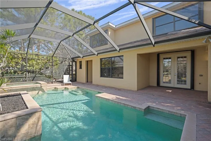 Integrated pool / spa featuring a sunroom, a patio, glass enclosure, and french doors