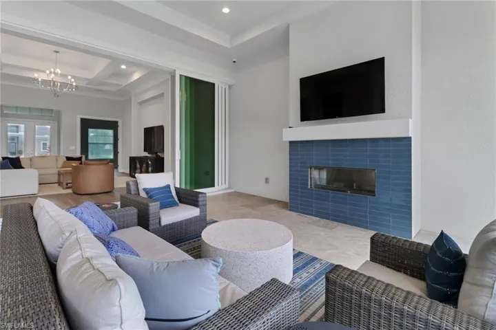Covered lanai with custom tiled fireplace with marble flooring.