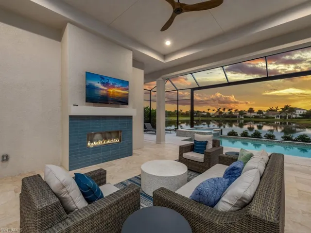 Custom gas fireplace with an inviting entertaining space with pool, spa and lake views beyond!
