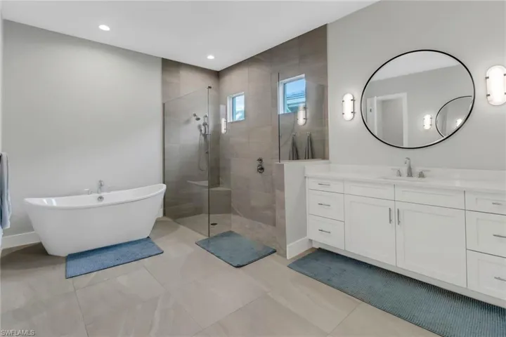 Primary bathroom featuring second vanity and plus walk in shower and separate tub.