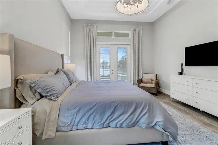 Primary bedroom featuring amazing views of the lanai and lake beyond.