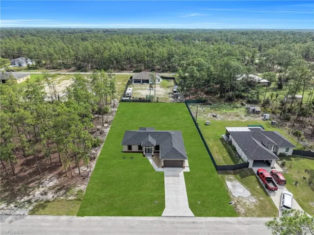 Single-story residence with a dark shingle roof, integrated garage, and a concrete driveway