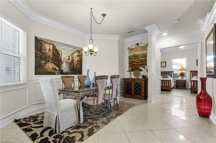 The dining area features elegant tile flooring, wainscoting, and crown molding