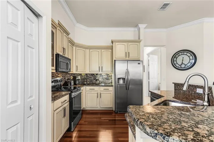 Well-appointed kitchen featuring granite countertops, stainless steel appliances, and wood flooring