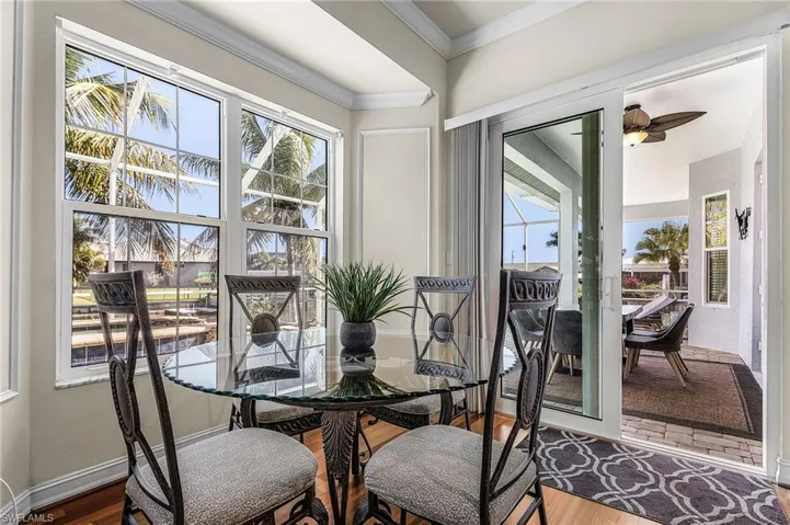 This dining area features large windows and a glass sliding door, offering abundant natural light and exterior views