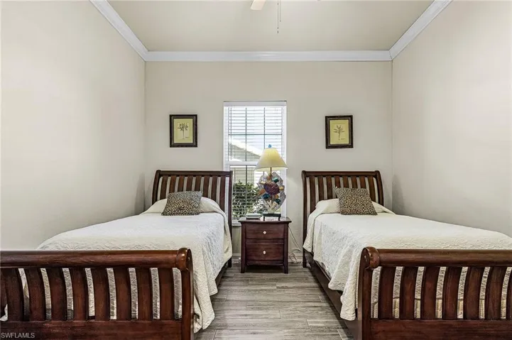This room features two wooden beds with slatted headboards and footboards, set against light-colored walls
