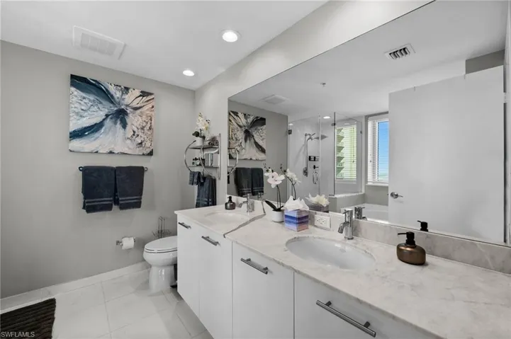 Full bathroom with independent shower and bath, vanity, and toilet