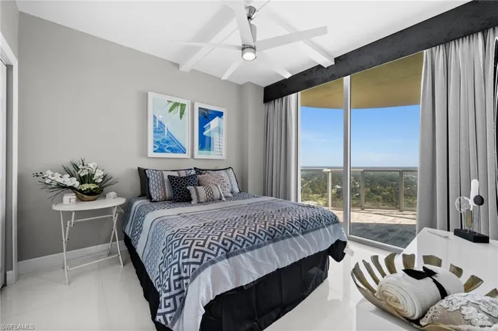 Bedroom with access to exterior, beamed ceiling, light tile patterned floors, and ceiling fan