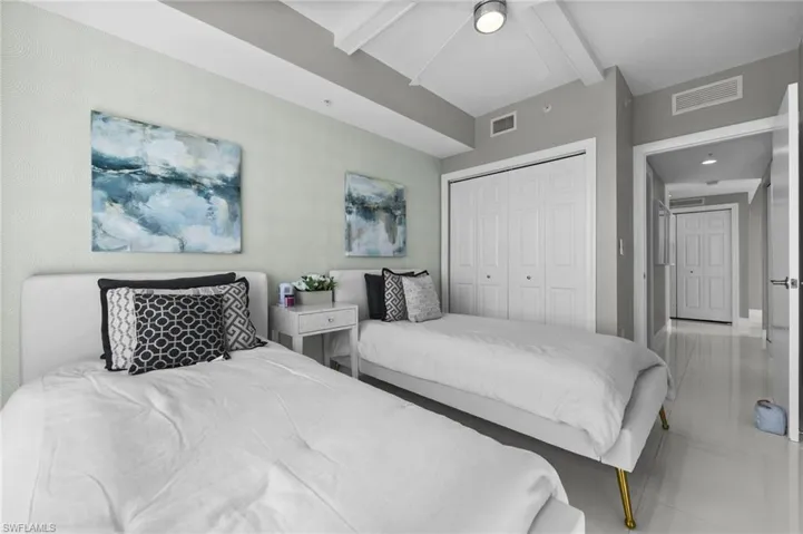 Bedroom with beamed ceiling, ceiling fan, and a closet