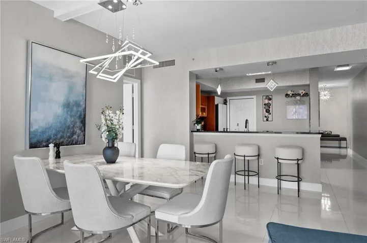 Tiled dining room featuring sink and a chandelier