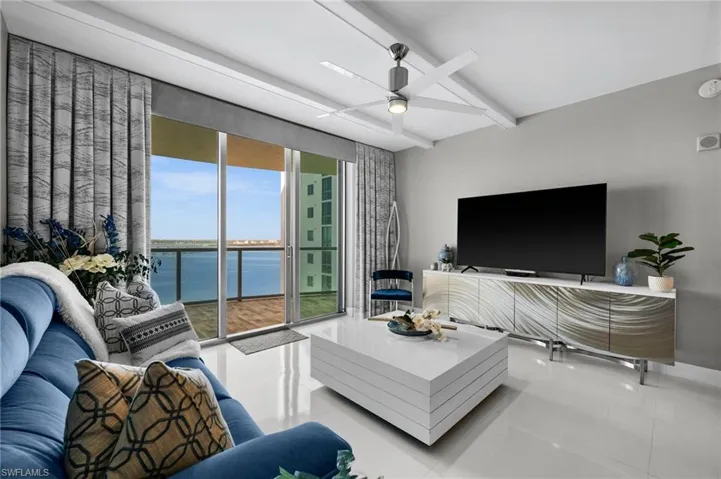 Living room with ceiling fan and tile patterned floors