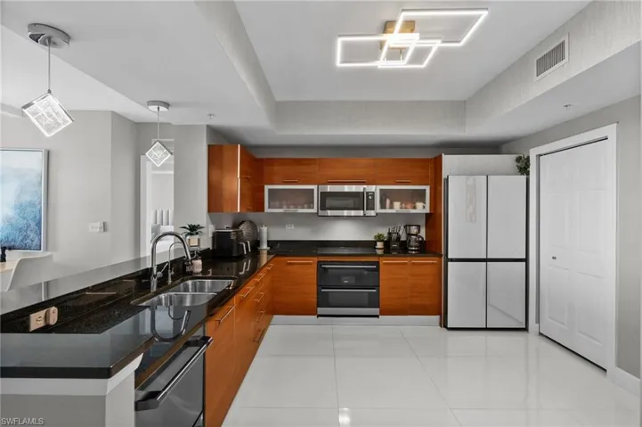 Kitchen featuring appliances with stainless steel finishes, pendant lighting, kitchen peninsula, and sink