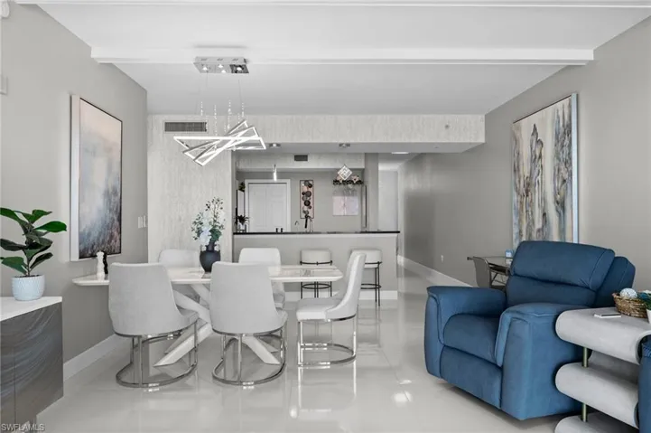 Tiled dining room with beam ceiling and an inviting chandelier