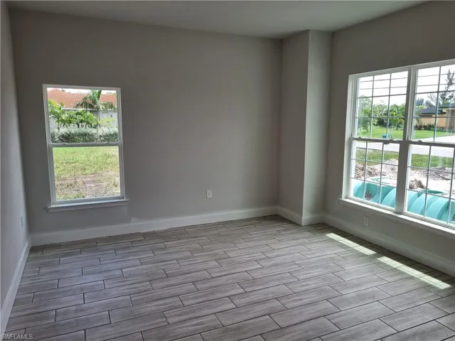 Empty room featuring light wood-type flooring and plenty of natural light