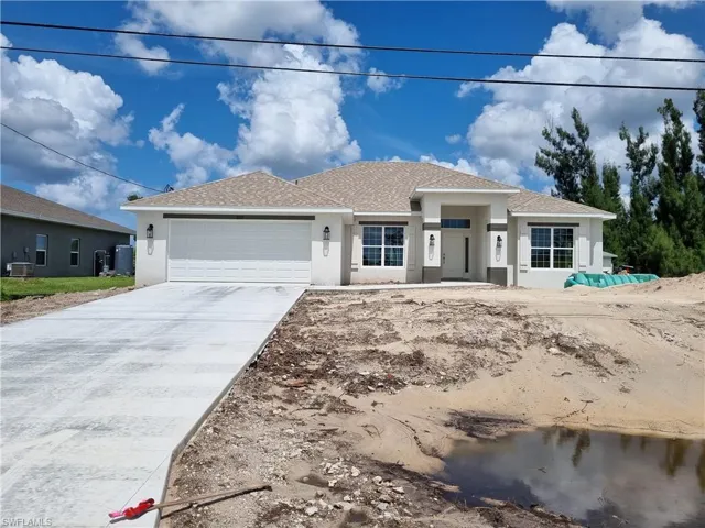 View of front of home featuring central AC and a garage