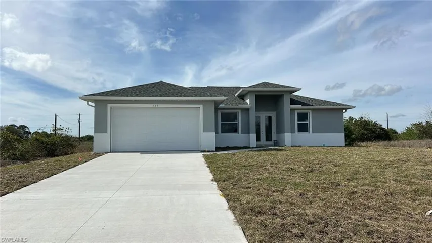 View of front of property featuring a front lawn and a garage