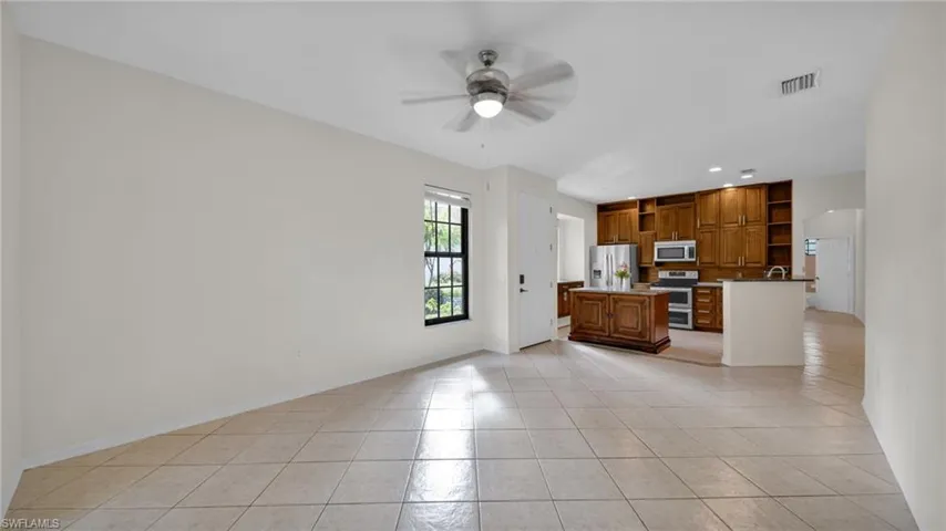 Kitchen with brown cabinetry, light tile patterned flooring, open shelves, ceiling fan, and recessed lighting
