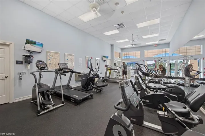 Gym featuring a drop ceiling and a high ceiling