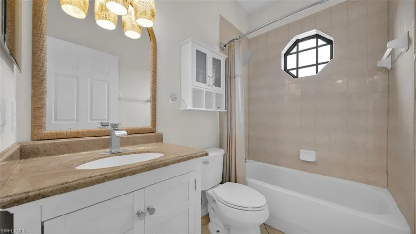 Bathroom with shower / bath combo with shower curtain, vanity, and a chandelier