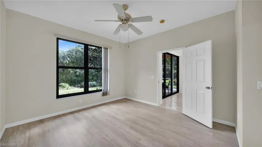Unfurnished room featuring healthy amount of natural light, light wood-type flooring, and ceiling fan