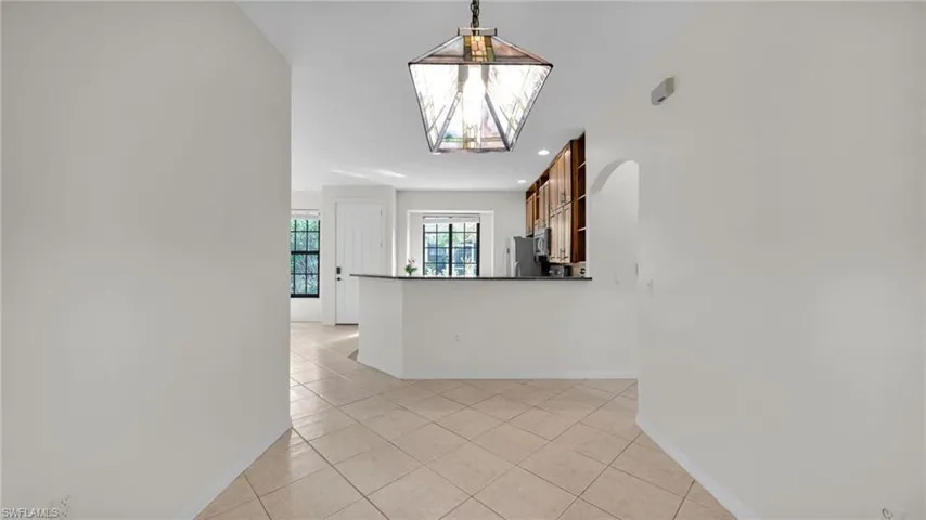 Hall with light tile patterned floors and recessed lighting