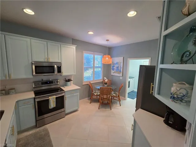 Kitchen featuring stainless steel appliances, hanging light fixtures, recessed lighting, open shelves, and white cabinets