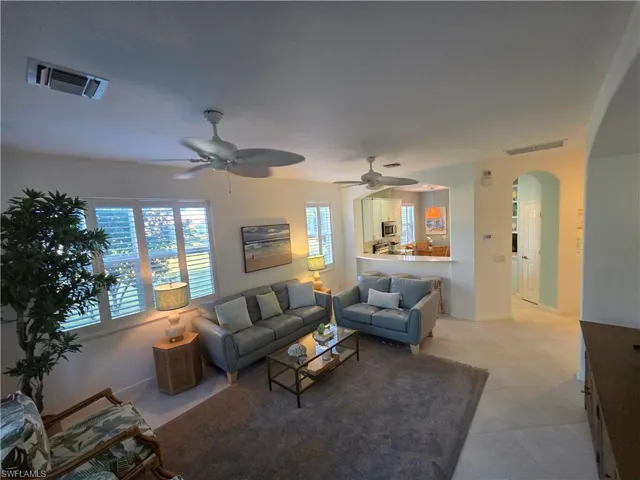 Living room featuring arched walkways and a ceiling fan