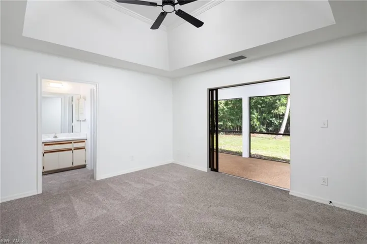 Primary bedroom featuring access to outside, carpet, ensuite bath, crown molding, and ceiling fan