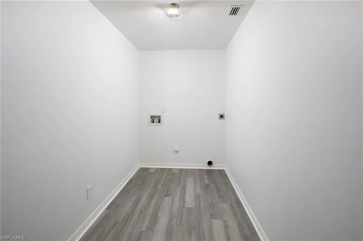 Laundry area with light wood finished floors, washer and dryer hookup.