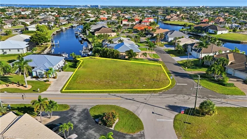 Aerial perspective of suburban area with property boundaries highlighted and a nearby body of water