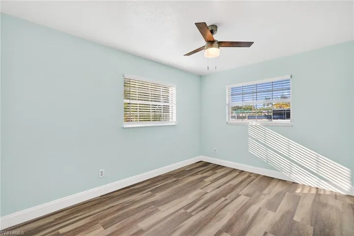 Empty room with wood finished floors and a ceiling fan