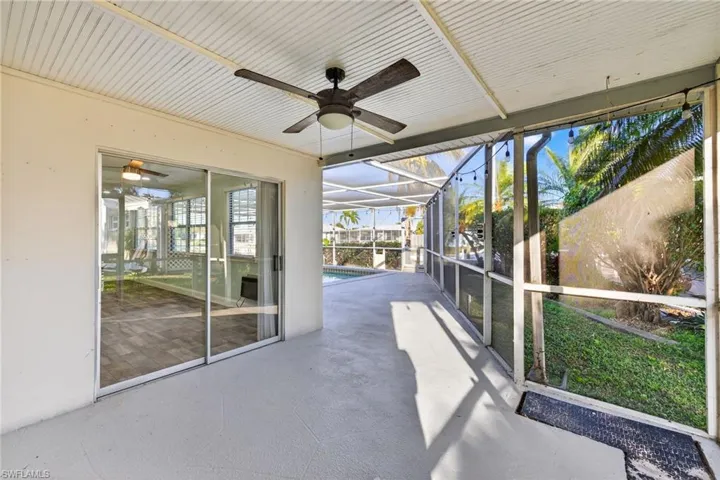 Unfurnished sunroom featuring a ceiling fan and a patio