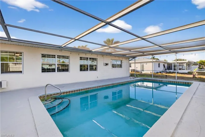 Outdoor pool featuring a lanai, a sunroom, and a patio area