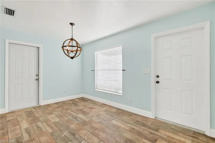 Foyer featuring light wood finished floors and a chandelier
