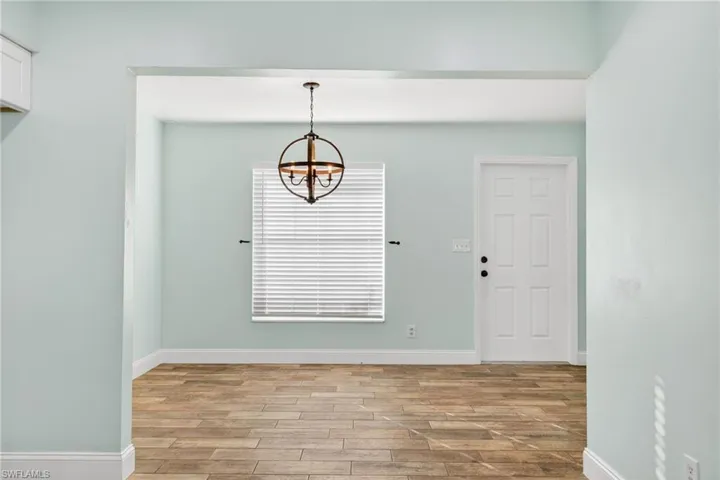Unfurnished dining area with a chandelier and light wood finished floors