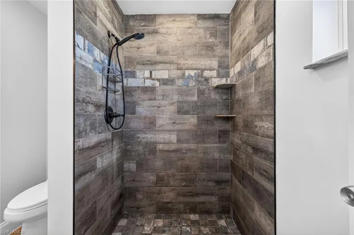 Full bathroom with toilet and tiled shower