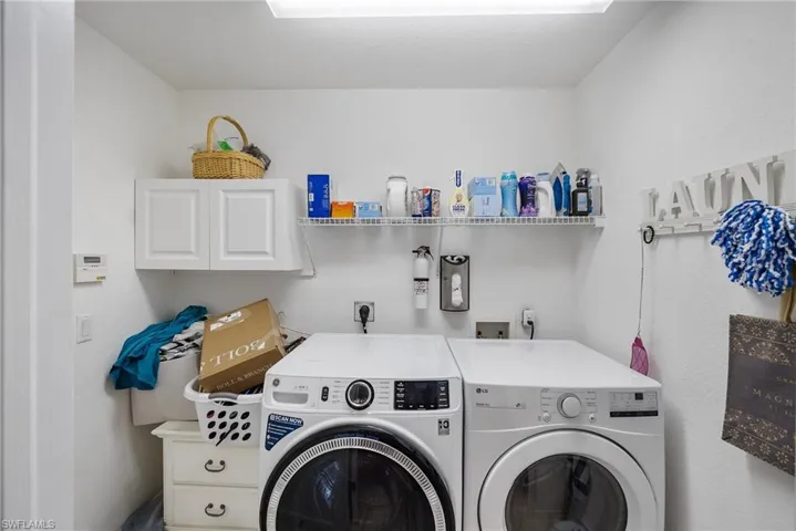 Laundry room leads to 2+ car garage with work bench and 220