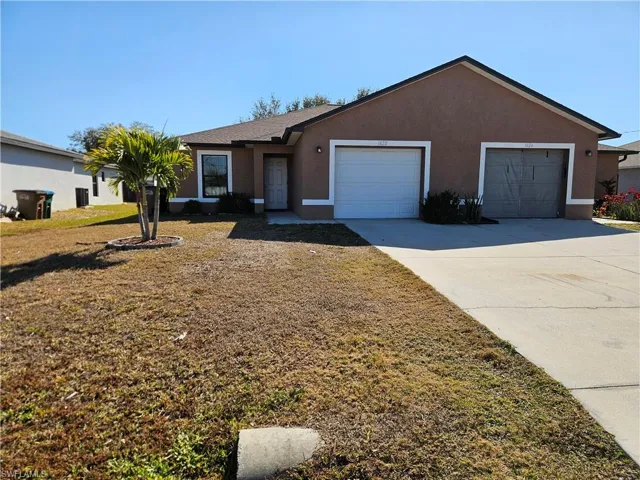 Ranch-style home featuring stucco siding, driveway, and a garage