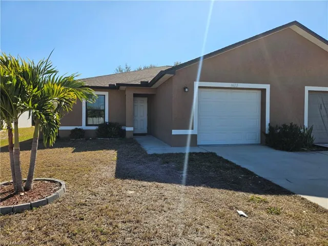Ranch-style home featuring stucco siding, driveway, an attached garage, and a shingled roof