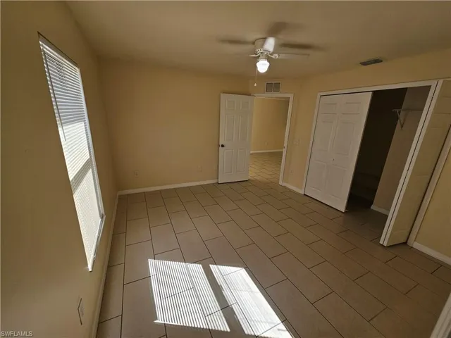 Unfurnished bedroom featuring ceiling fan and a closet