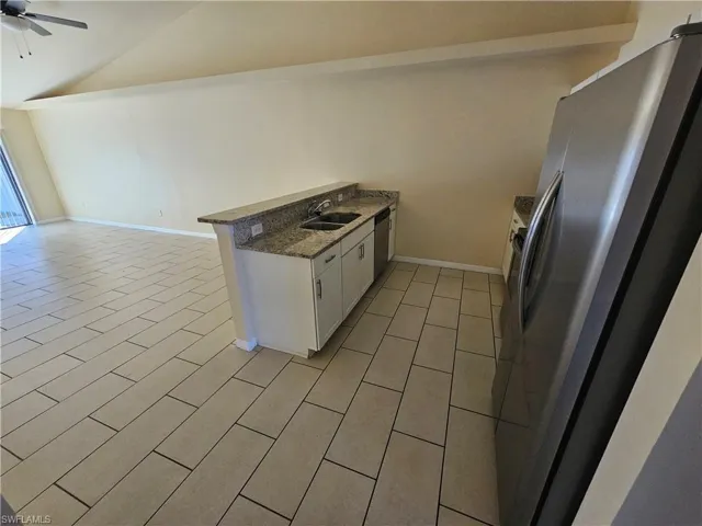 Kitchen featuring white cabinetry, stainless steel appliances, a peninsula, ceiling fan, and open floor plan