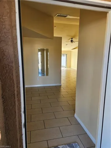 Corridor featuring light tile patterned floors
