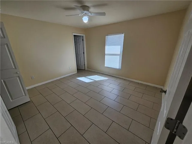 Unfurnished bedroom featuring a ceiling fan and light tile patterned floors