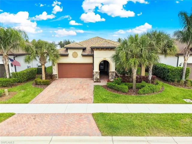 Mediterranean style house with stucco  siding, decorative  stone,  garage, and pavers in driveway  and entry walk