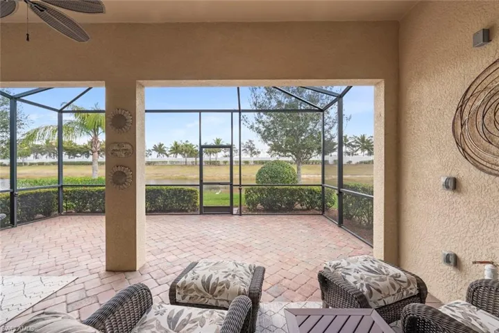 View of patio / terrace with a bronze screen enclosure, night lighting,  and ceiling fan